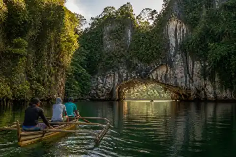 Boats on a river near limestone karst and a natural bridge in Sohoton, Basey, Samar