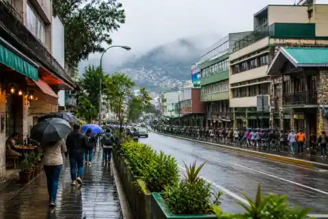 Pedestrians walking along Session Road slope with shops and cafés in Baguio