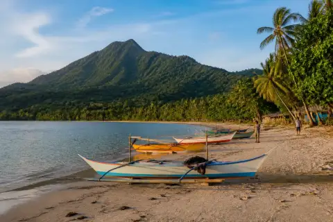 Buaya Beach on Sicogon Island with small boats and Mount Opao ridge