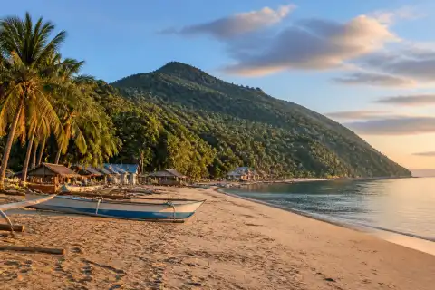 Buaya Beach on Sicogon Island with wooden boats and Mt. Opao in the background
