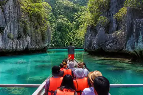 Small banca entering a narrow limestone passage in Sohoton Cove, Bucas Grande