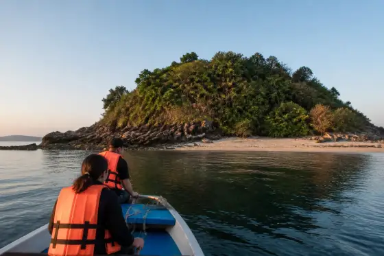 Small boat approaching Sombrero Island's exposed shoreline at dawn