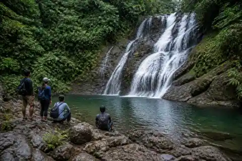 Forest waterfall and pool in Sorsogon with hikers