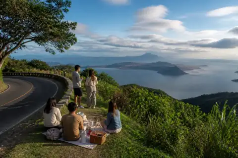 Taal Volcano and Lake viewed from a Tagaytay ridge viewpoint with picnic-goers