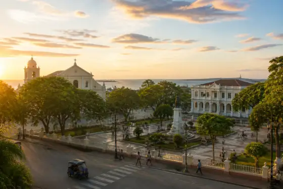 Plaza Rizal with St. Joseph Cathedral and a passing tricycle at golden hour in Tagbilaran