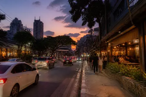 Evening view of Tomas Morato Avenue with restaurants, pedestrians and traffic