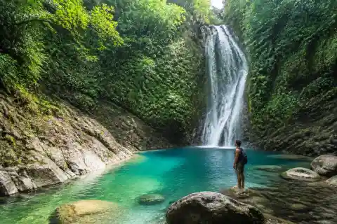 Turquoise plunge pool beneath a ravine waterfall in Mindanao