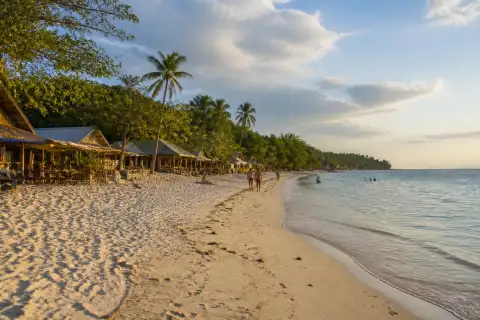 White Beach Basdaku shoreline with sand, cottages and sunset light