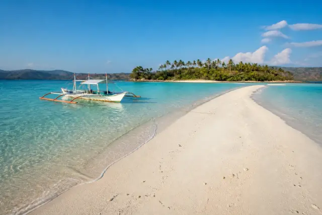 Ditaytayan sandbar with turquoise water and a small boat, Culion