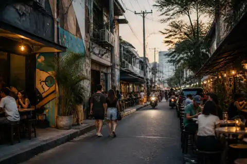 Poblacion street at dusk with outdoor bars, murals and pedestrians