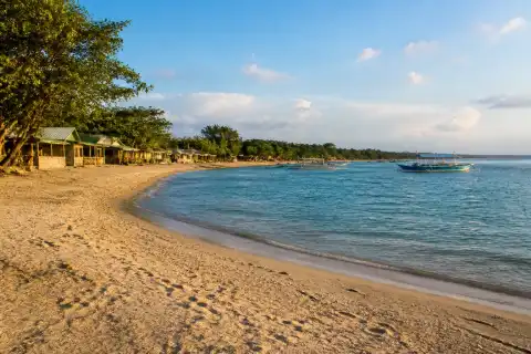 Quiet Bolo Beach shoreline with low-rise cottages and calm water at Alaminos