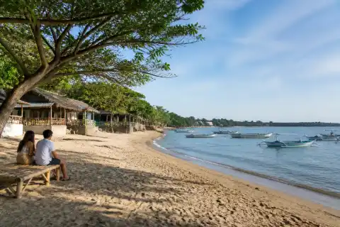 Quiet Bolo Beach shoreline with low-rise cottages and calm water in Alaminos
