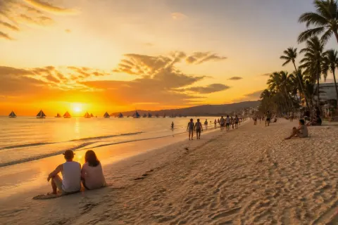 White Beach, Boracay at sunset with paraw boats silhouetted on the horizon