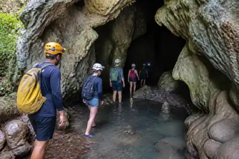 Entrance of Calabidongan Cave in Camalig with guide and cavers at a wet rocky passage