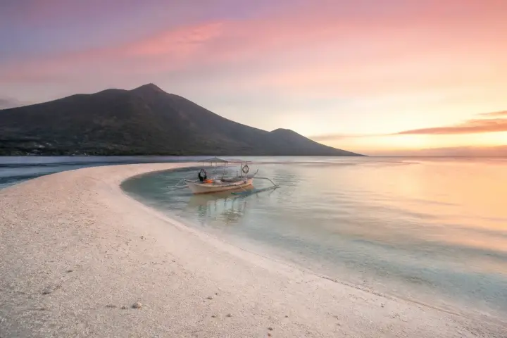 White Island sandbar with Camiguin volcano silhouette at sunrise