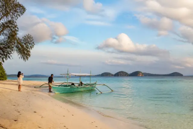 Pale sand and shallow turquoise water on Candaraman Island beach