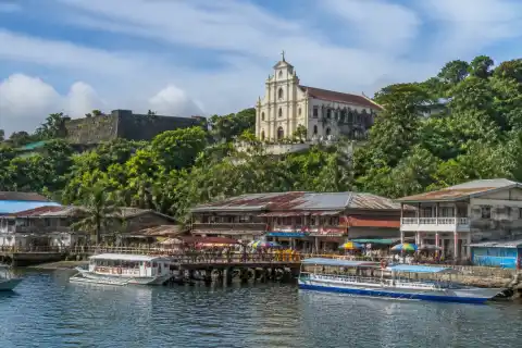 Culion waterfront with boats and La Immaculada Concepcion Church on the hillside