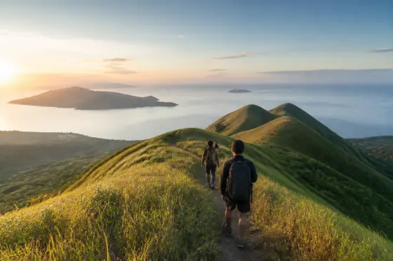 Hikers on a grassy ridge with sea views in Leyte