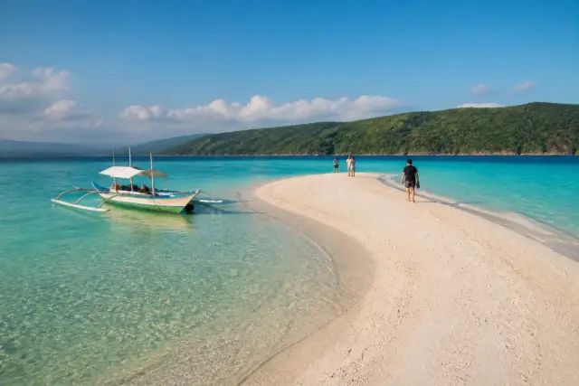 Sumilon Island white sandbar with a banca and visitors in clear turquoise water