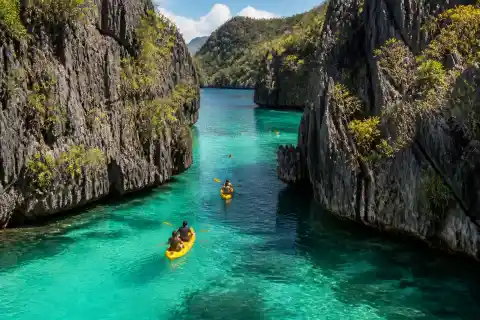 Kayaks passing through the narrow limestone channel at Twin Lagoon, Coron
